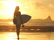 夕阳下走在沙滩上的冲浪者超清唯美桌面屏保图片