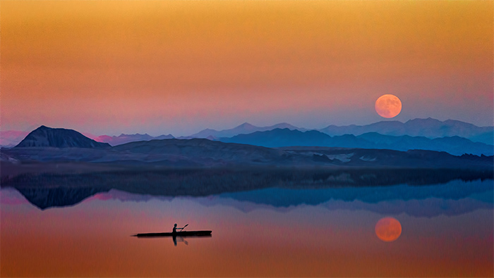 夕阳下平静湖面上独自划船的渔民超清唯美桌面壁纸图片